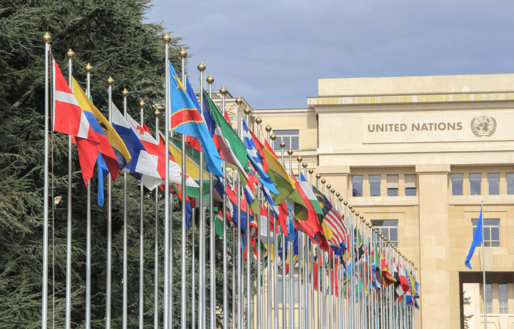 United Nations building with flags representing international collaboration on artificial intelligence. Global context for US federal AI governance policy and AI governance laws